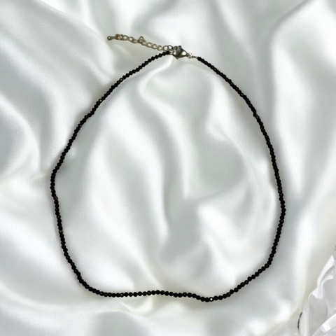 My Two Daughters Jewelry - Black beaded necklace on a white satin background