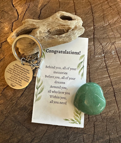 Fancy Beads - A set of personalized keychains with messages intended for a daughter on graduation, displayed alongside a piece of driftwood and a heart-shaped crystal.