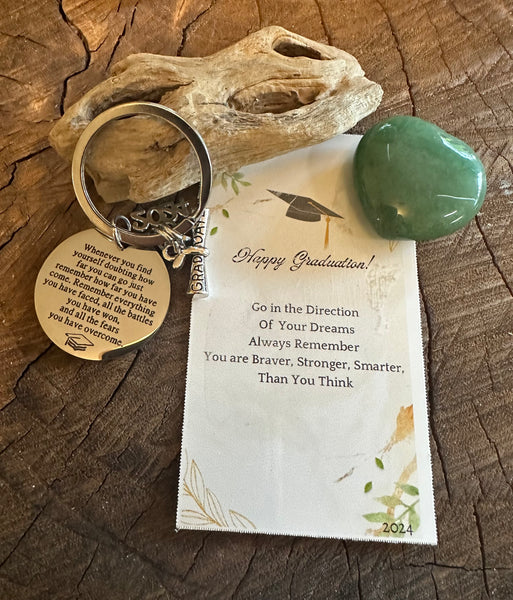 Fancy Beads - A set of personalized keychains with messages intended for a daughter on graduation, displayed alongside a piece of driftwood and a heart-shaped crystal.