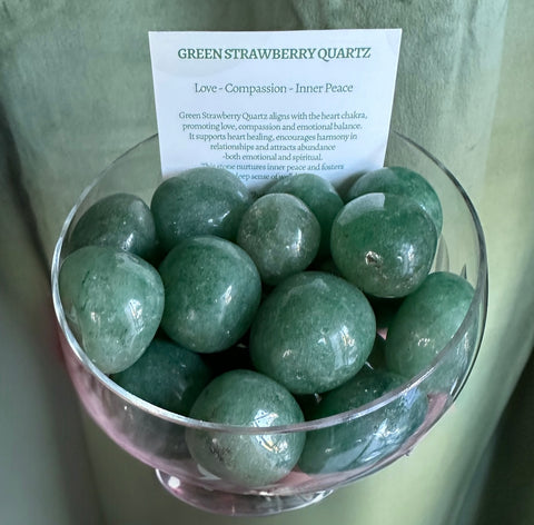 Kelowna Crystal Cave - Green strawberry quartz stones in a glass bowl with a card explaining the properties of the stone.