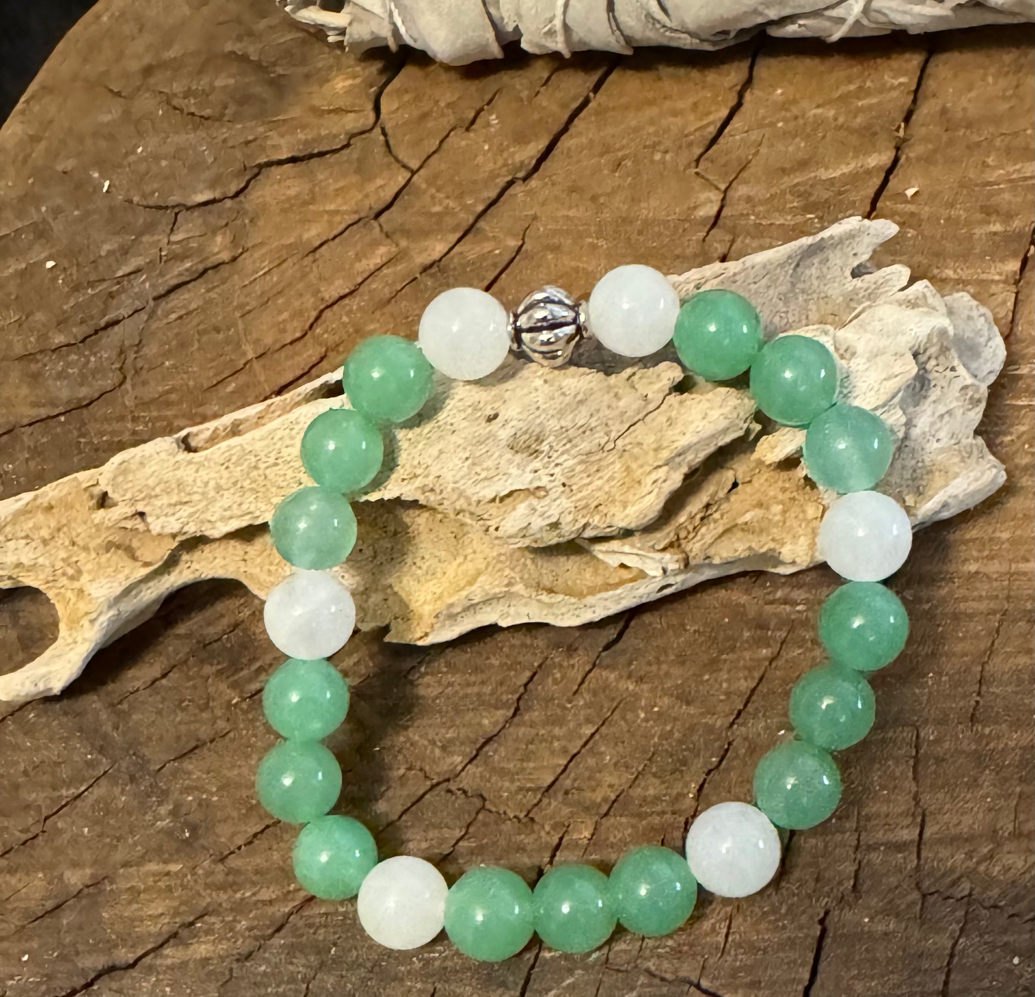 My Two Daughters Jewelry - A bracelet with green aventurine and white jade beads, displayed on a wooden surface.