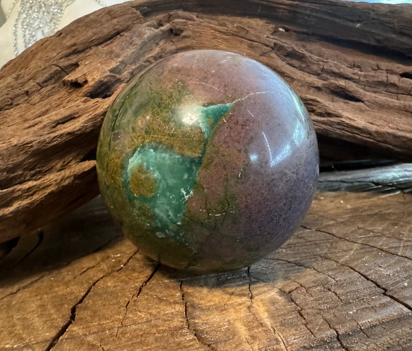 Kelowna Crystal Cave - Nephrite Jade Sphere on wooden surface