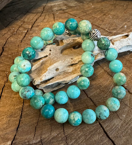 My Two Daughters Jewelry - A bracelet with round turquoise beads and a silver clasp, displayed on a wooden surface.