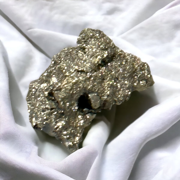 Kelowna Crystal Cave - A small Pyrite cluster displayed on a white cloth