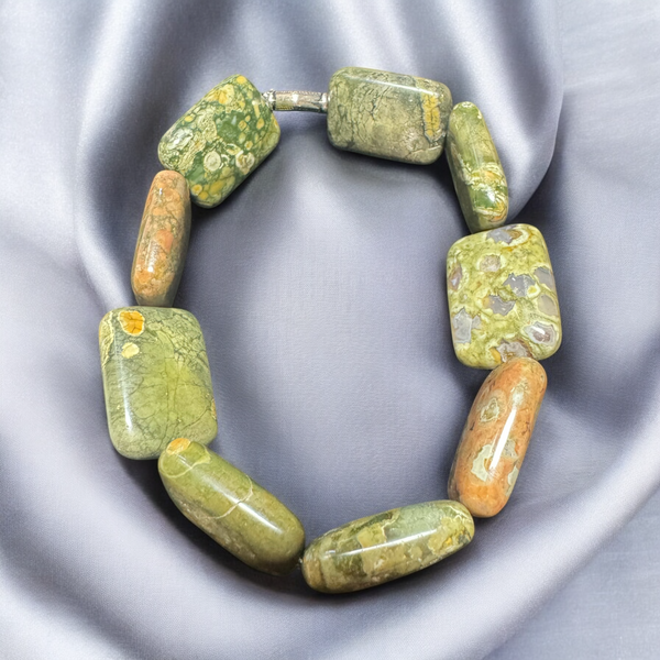 My Two Daughters Jewelry - A bracelet made of rhyolite stones, displayed on a silky gray background.