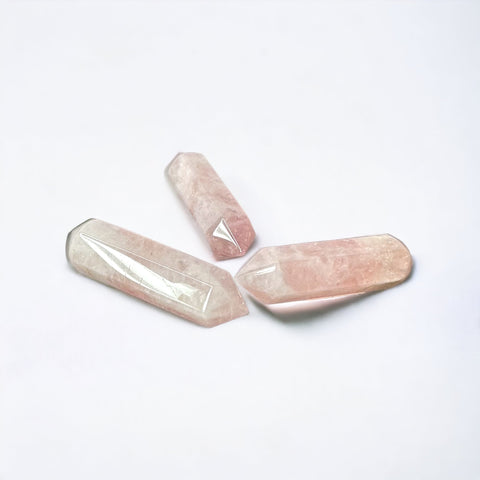 Kelowna Crystal Cave - A collection of polished rose quartz pencil points in various shades of pink and white, displayed on a white background.