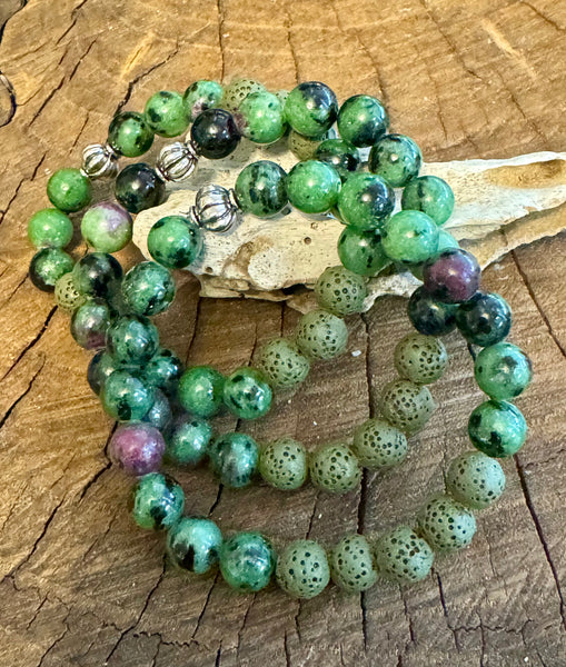 My Two Daughters Jewelry - A multicolored beaded bracelet made of Ruby Zoisite and Lava Stone beads, displayed on a wooden surface.