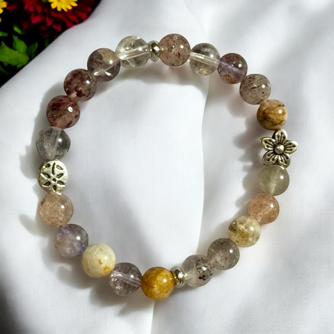 My Two Daughters Jewelry - A bracelet made with round beads of varying colors and textures, featuring metallic accents with floral and geometric patterns.