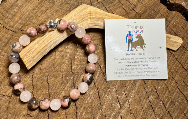 My Two Daughters Jewelry - Beaded bracelet with pink and white stones on a wooden surface next to a Taurus zodiac card.