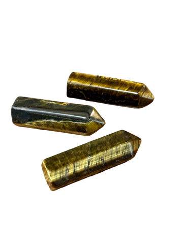 Kelowna Crystal Cave - A collection of small tiger's eye stones with a pointy shape, displayed on a white background.