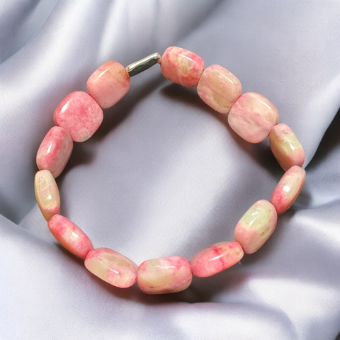 My Two Daughters Jewelry - A bracelet made of pink ice rhodonite stones, displayed on a silky gray background.
