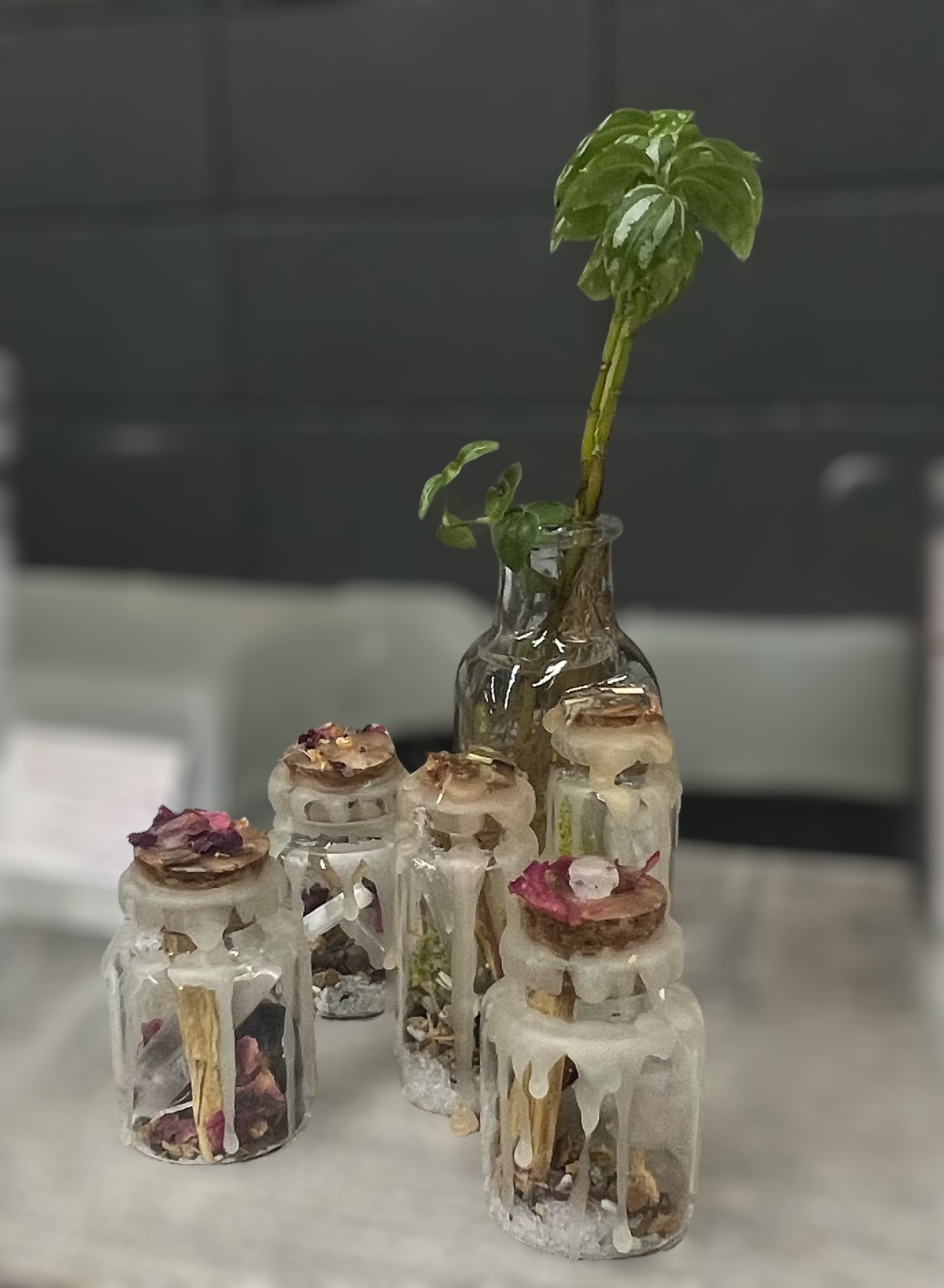 Kelowna Crystal Cave - Collection of small glass protection and self love jars with various crystlas on a table.