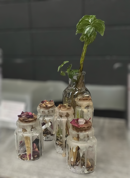 Kelowna Crystal Cave - Collection of small glass protection and self love jars with various crystlas on a table.