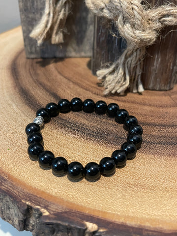 My Two Daughters Jewelry - A black agate bracelet with 8mm beads displayed on a wooden surface.