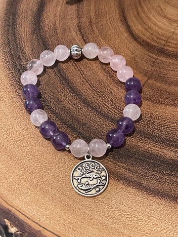 My Two Daughters Jewelry - A bracelet with round beads in shades of purple and pink, featuring a silver-colored Pisces zodiac charm.