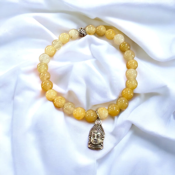 My Two Daughters Jewelry - A bracelet made of round yellow topaz stones, displayed on a white fabric surface.