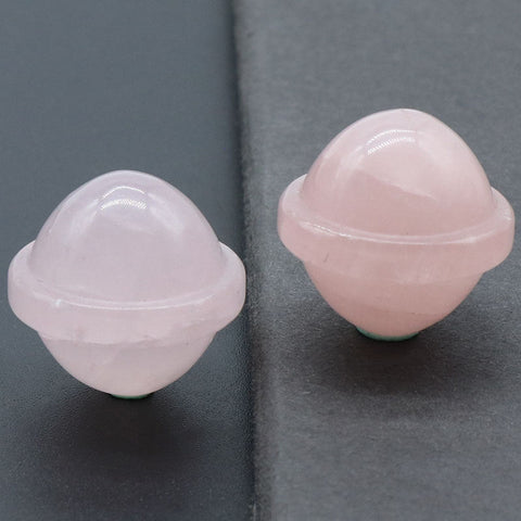 Kelowna Crystal Cave - Two polished pink rose quartz planet gemstones with a smooth finish, displayed against a grey background.